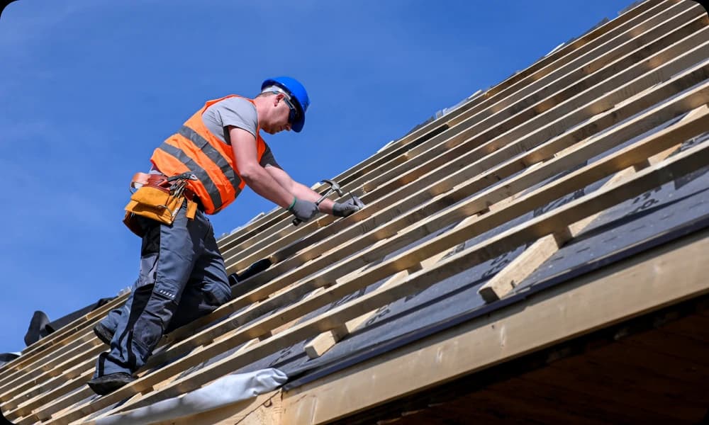 Specialist on a roof repairing and replacing old roof with new one